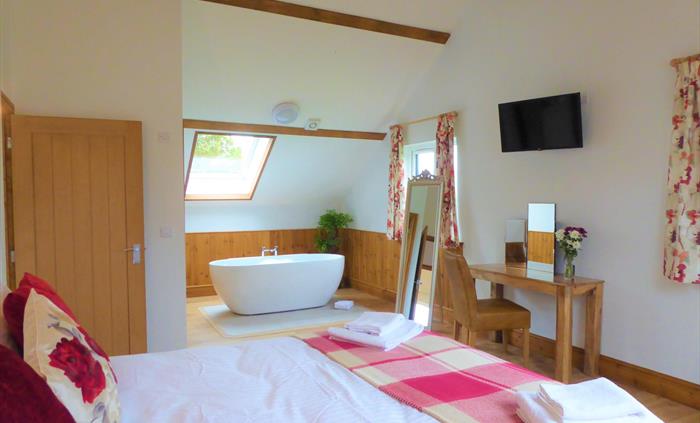Bedroom 2 (upstairs) with superking size bed or 2x single beds smart tv and freestanding bathtub.  Adjoining is an ensuite room with walk in shower.